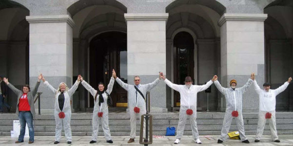 Six protesters in bloodstained suits oppose the genital mutilation of baby boys